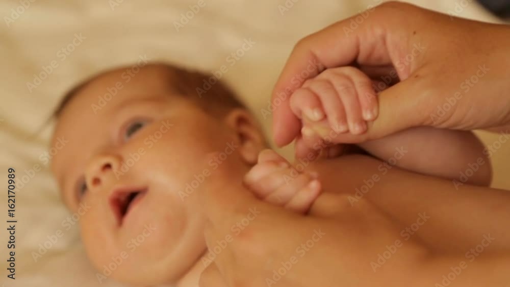 Mom tenderly embraced the baby's small hands Mom tenderly embraced the baby's small hands
