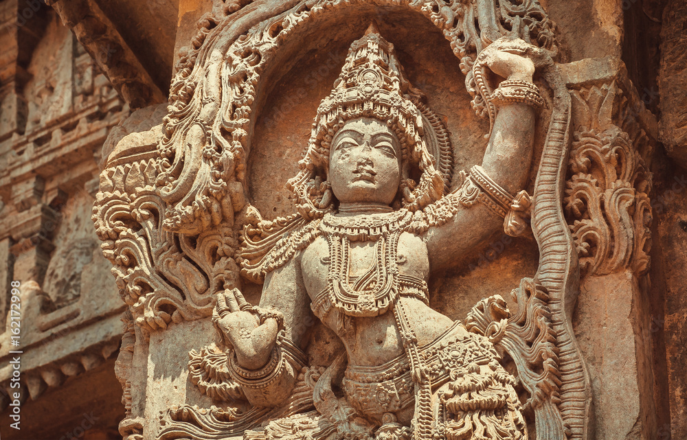 Indian Architecture of 12th century. Woman dancing in traditional style on stone sculptured decoration inside the Hindu temple Hoysaleshwara in Halebidu, India.