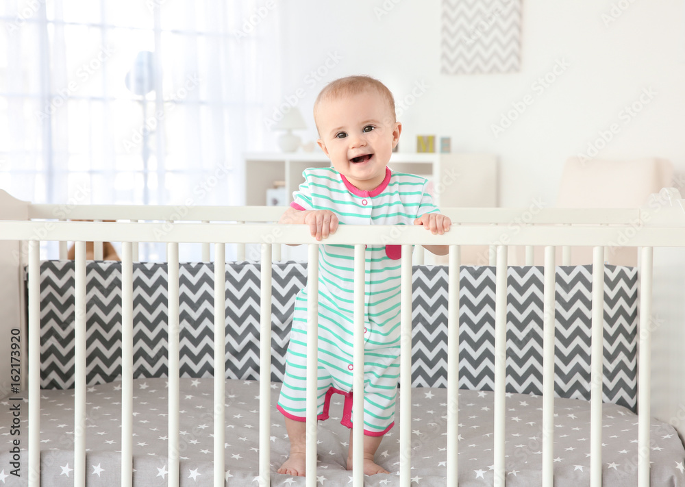 Cute little baby standing in crib at home Cute little baby standing in crib at home