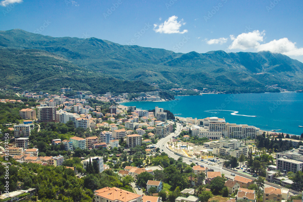 Budva city in Montenegro surrounded by mountains landscape. Roof tops seen from above.