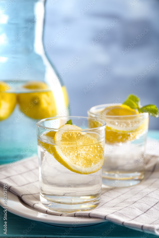 Composition with cold lemon water on wooden table, closeup