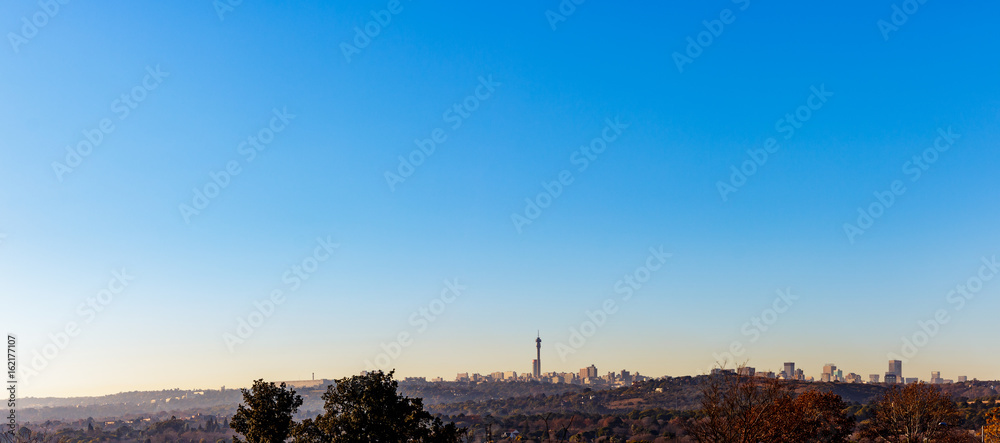 Fototapeta premium Northcliff view of Johannesburg City Skyline panorama on a winter morning with mist low and clear skies
