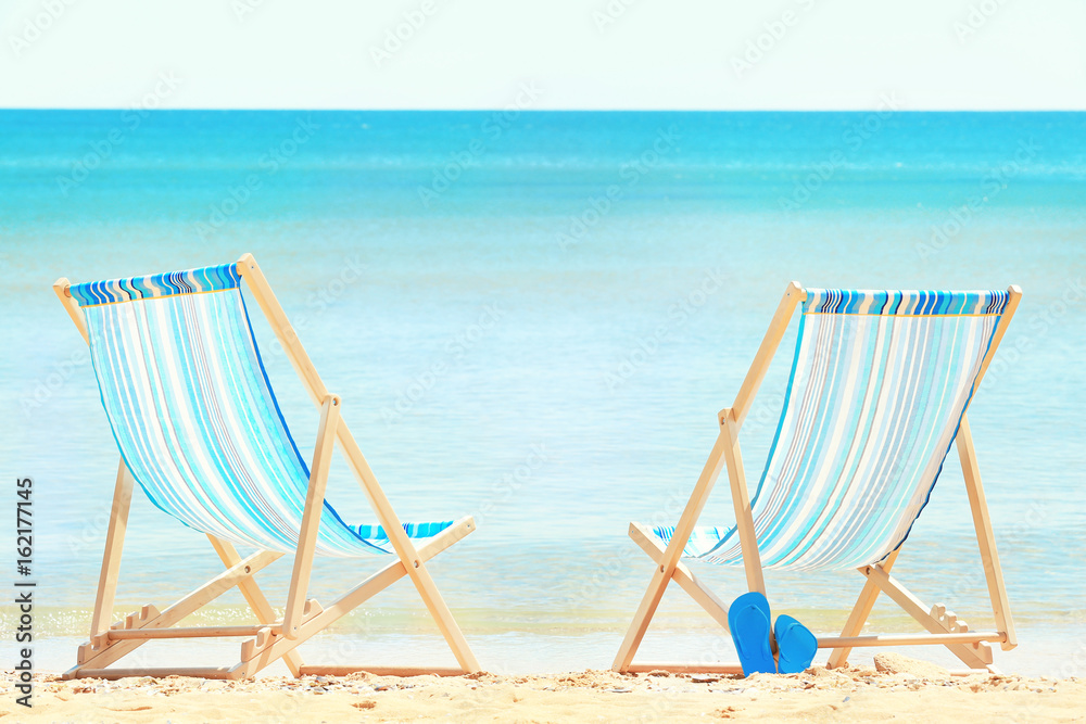 Pair of beach chairs at sea shore. Vacation concept Pair of beach chairs at sea shore. Vacation concept