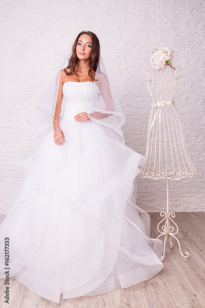 Beautiful woman in wedding dress pose in studio Beautiful woman in wedding dress pose in studio
