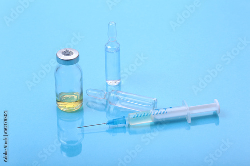 Syringe and Medical ampoules, vaccine on table.