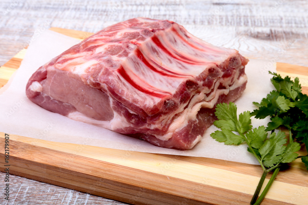 Raw pork chops, spices and basil on cutting board. Ready for cooking. Raw pork chops, spices and basil on cutting board. Ready for cooking.