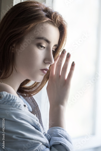 sensual sad female portrait with near window