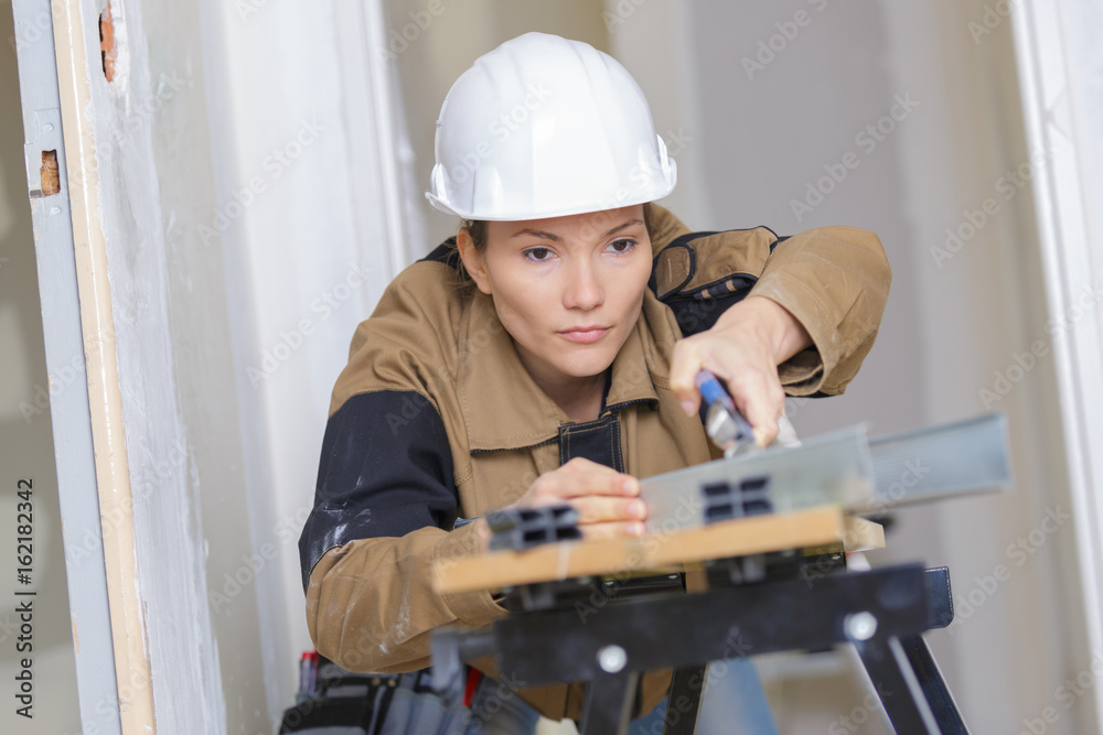 female builder using a machine electronic table saw cutting female builder using a machine electronic table saw cutting
