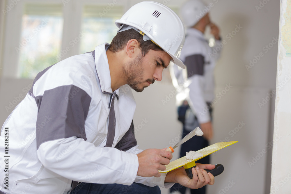 construction industry worker with tools plastering walls construction industry worker with tools plastering walls