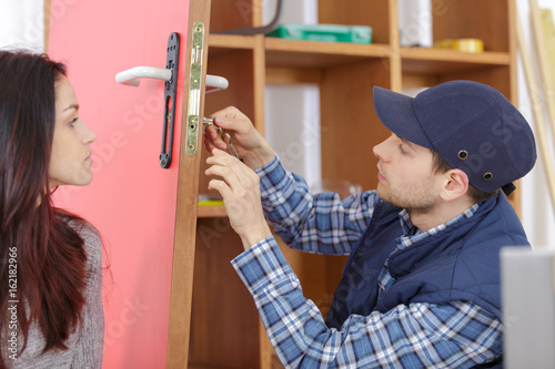 Foto young professional showing key locker system to female client