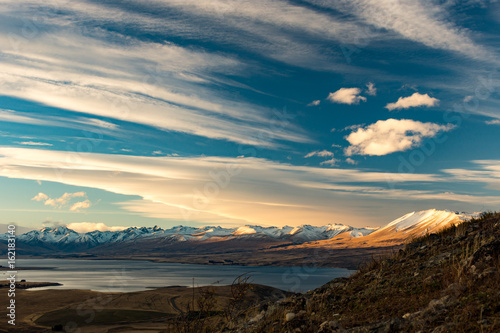 view of the mountains  lake and valey in a sunny day from mount john  lake tekapo