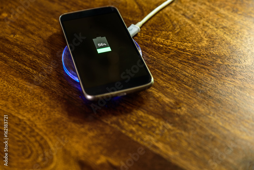 Smartphone charging on a charging pad. Wireless charging