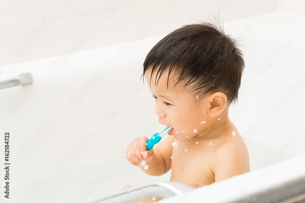 Asian baby uses toothbrush in the bathroom Asian baby uses toothbrush in the bathroom
