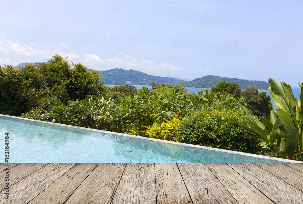wooden floor with swimming pool overlooking view andaman sea mountains and blue sky background,summer holiday background concept.