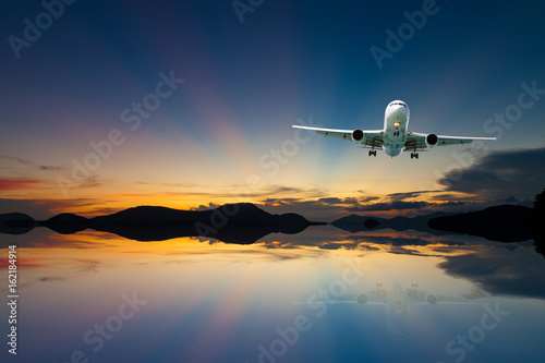 airplane in the sky with reflex beautiful sunset,concept open season tour and travel background.