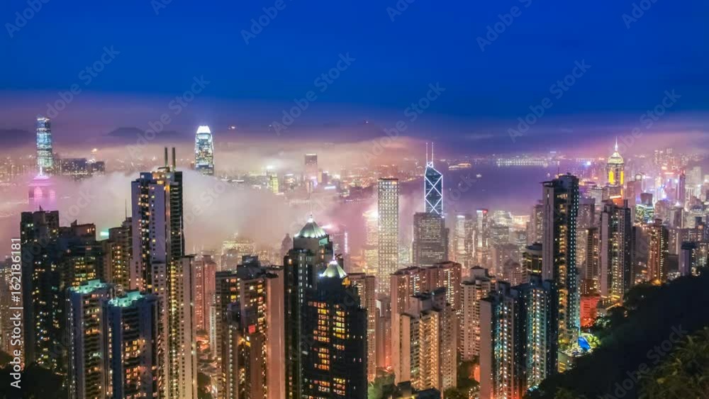 Time lapse Hong Kong skyline from famous Peak View at night. Fog rushing into the city. 