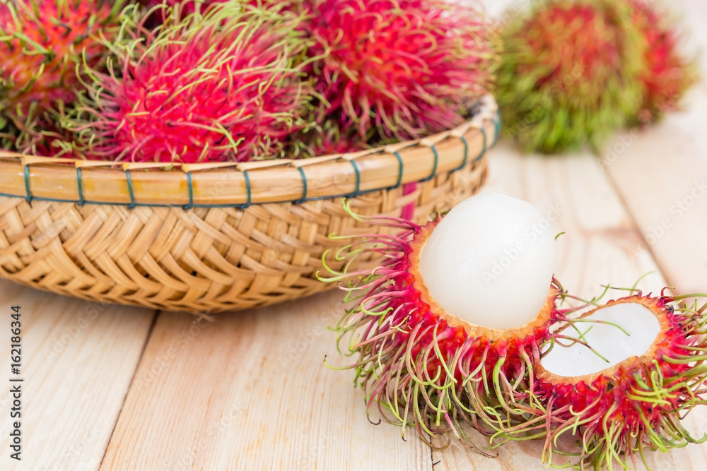 fresh tropical rambutan fruits over basket with knife on wood background, fruit in Thailand fresh tropical rambutan fruits over basket with knife on wood background, fruit in Thailand