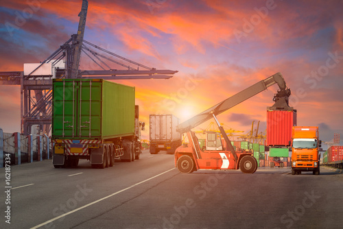 Logistics and transportation of Container Cargo ship and Cargo plane with working crane bridge in shipyard at Twilight sky, logistic import export background and transport industry.