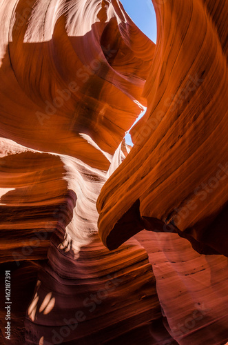 Orange peach wave shapes photographed at slots canyons in Arizona with blue sky