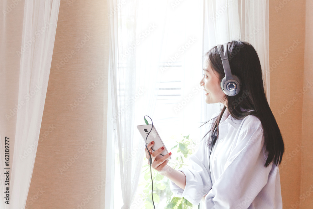 Naklejka premium Woman listening music with headphones