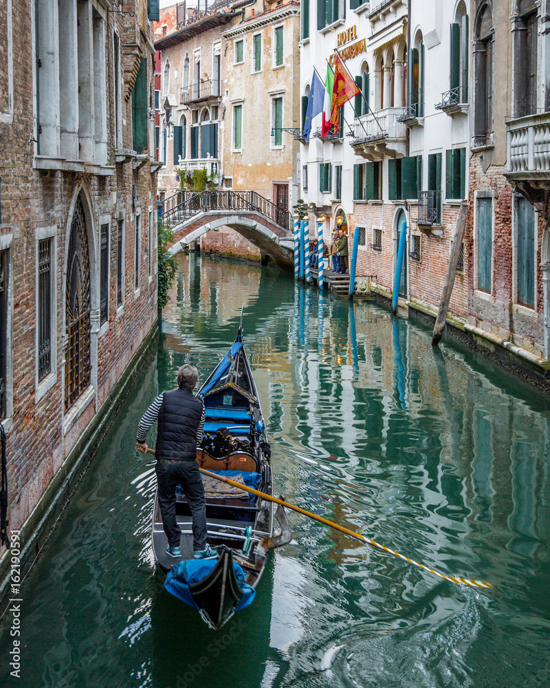 Gondolier navigating Gondola Through Canals of Venice