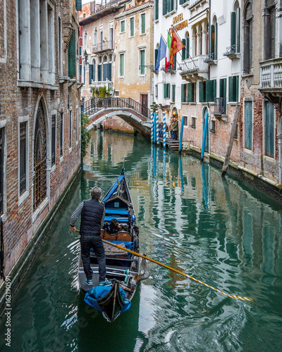 Gondolier navigating Gondola Through Canals of Venice © Quattrophotography