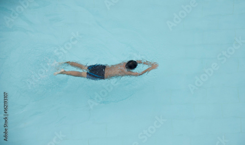 Top View A Boy Is Swimming In A Pool