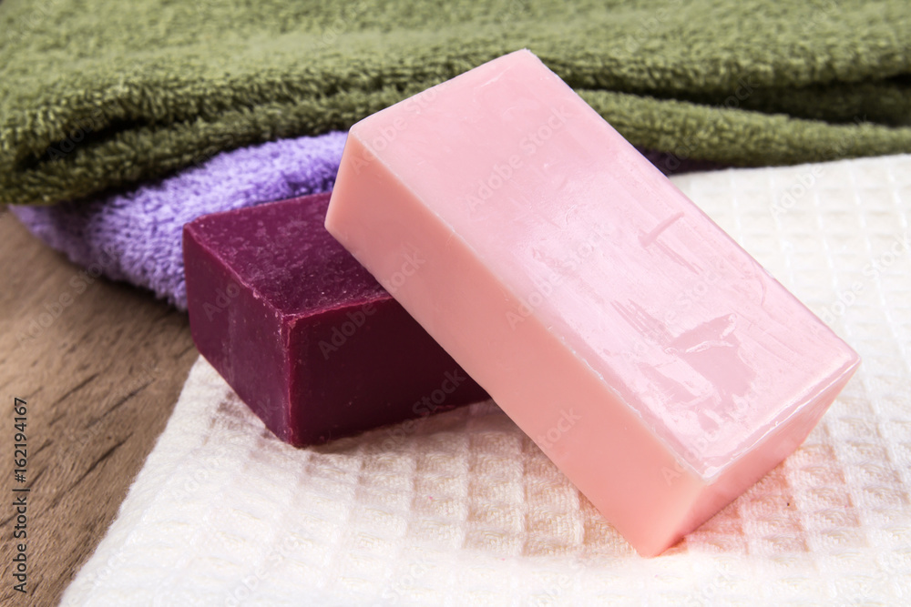 natural soap bar with bath towel on wooden background natural soap bar with bath towel on wooden background