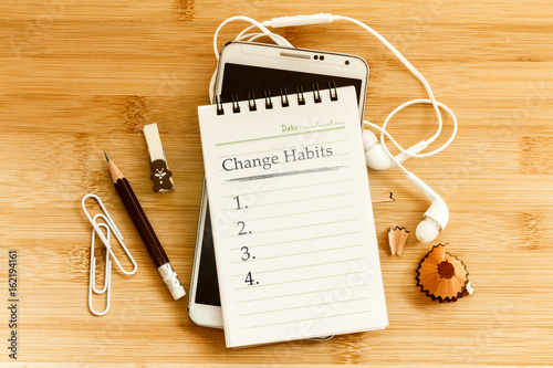 Hand written  Change habits message notepad with the  pencil  on wooden table for change habits  list for good life concept , overhead shot or Top view photo