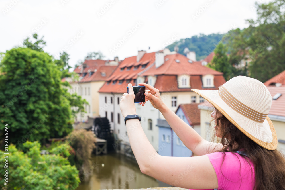 woman taking picture of Old Town in Prague with a smartphone.