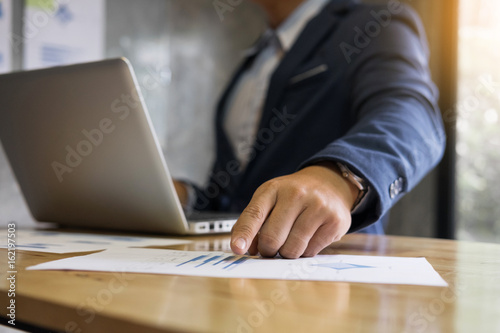 Business team analyzing income charts and strategy graphs documents on office table with digital tablet and graph financial with social network diagram and man working in the office background