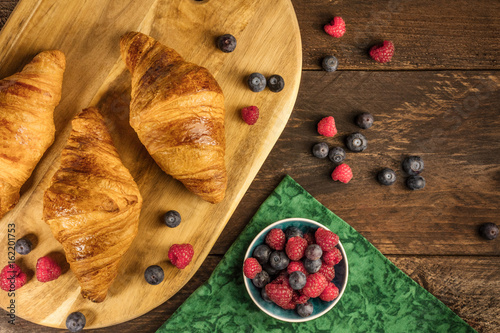 Crunchy French croissants with fresh raspberries and blueberries