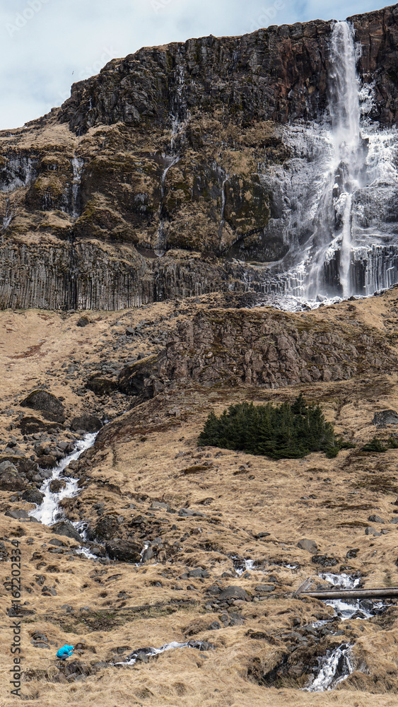 Trekking man scale with majestic waterfall mountain size. How powerful nature is compare to human Trekking man scale with majestic waterfall mountain size. How powerful nature is compare to human