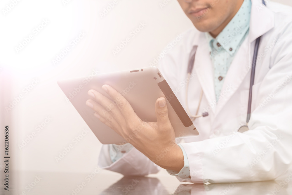 Doctor with a stethoscope touching tablet,Len flare effect Doctor with a stethoscope touching tablet,Len flare effect