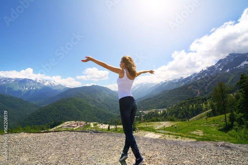 Happy young traveler woman backpacker raised arm up