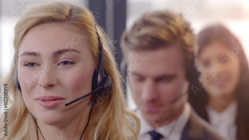 Call Centre Agents working in their bright office Friendly Call Centre Agents working in their office. Shot in 4k with a red dragon down convert to HD.