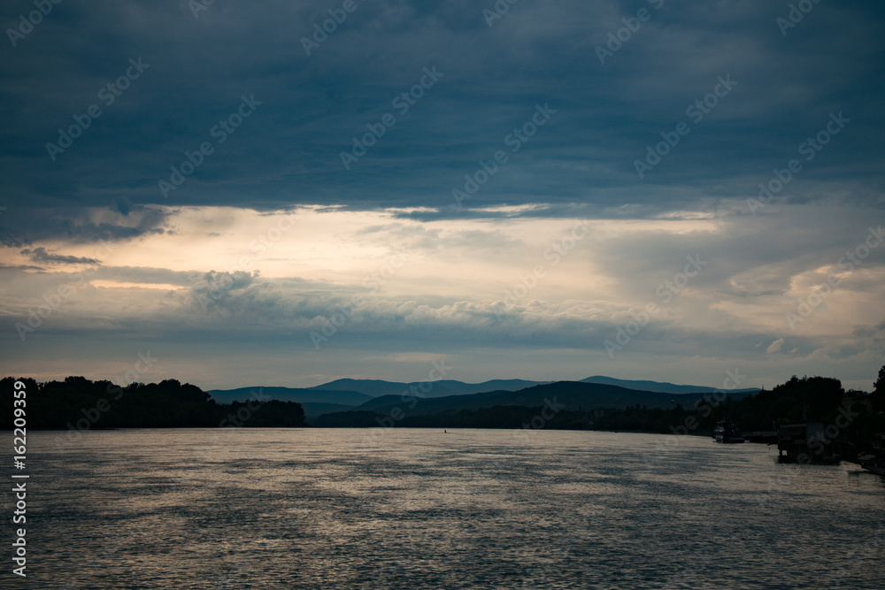 Beautiful landscape. Sunset clouds over Danube river