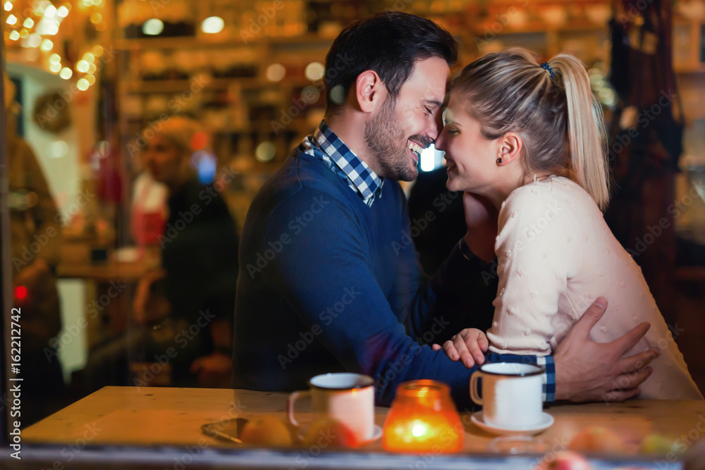 Happy couple kissing at bar and having date Happy couple kissing at bar and having date