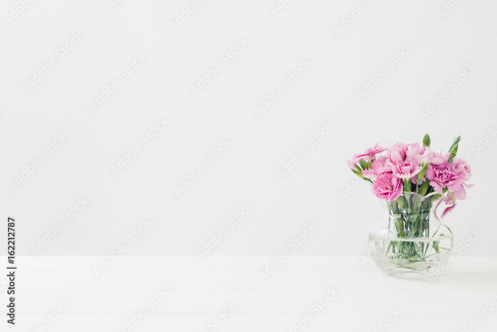 bouquet of pink Carnationflowers in vase on white table. Empty space for text