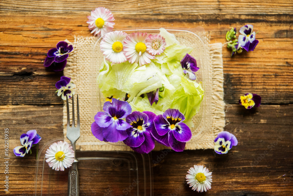 Spring salad with radishes, edible flower and sauce, selective focus Spring salad with radishes, edible flower and sauce, selective focus