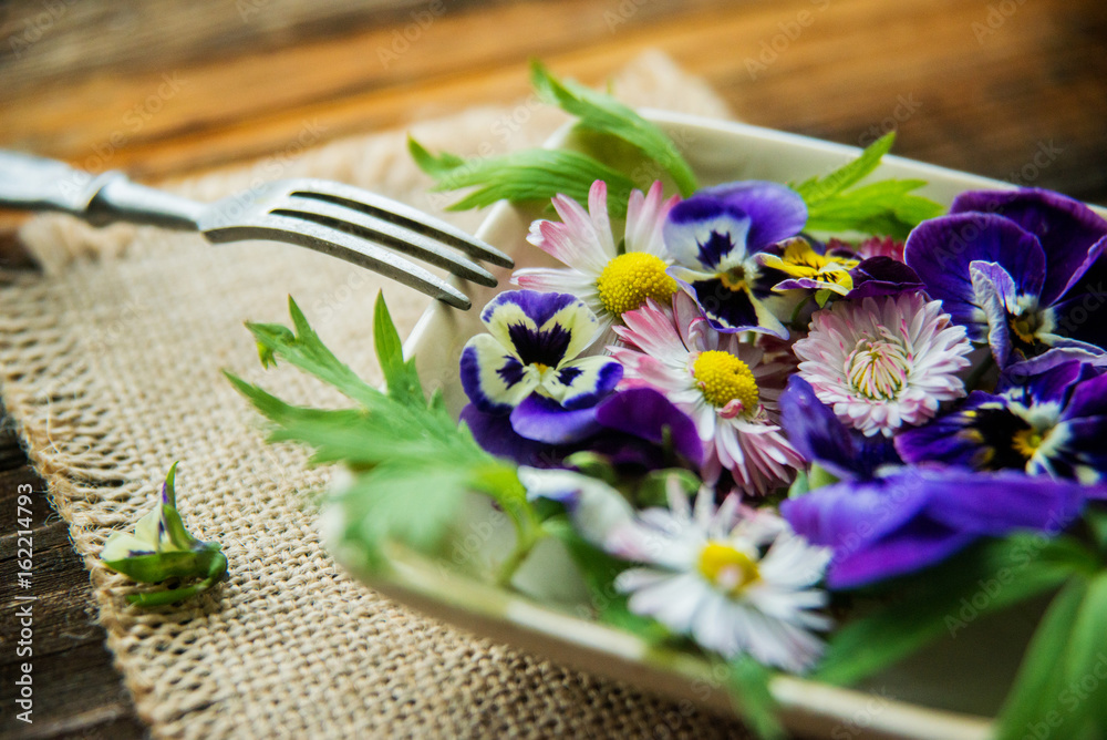 Sunflower sprouts, cucumber and edible flowers salad on wooden bowl Sunflower sprouts, cucumber and edible flowers salad on wooden bowl