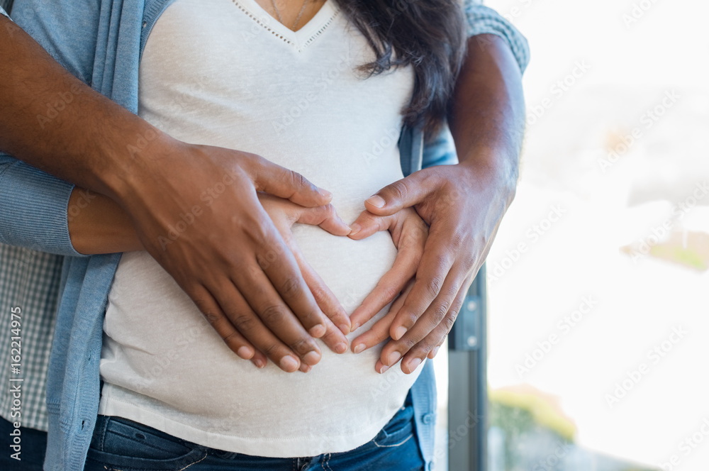 Multiethnic couple expecting a baby - obrazy, fototapety, plakaty 