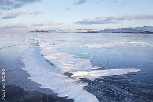 Winter landscape of Lake Baikal, snow on crack in ice.