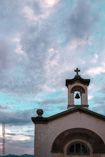 White church under cloudy sky at sunset. Sardinia. Italy. photo