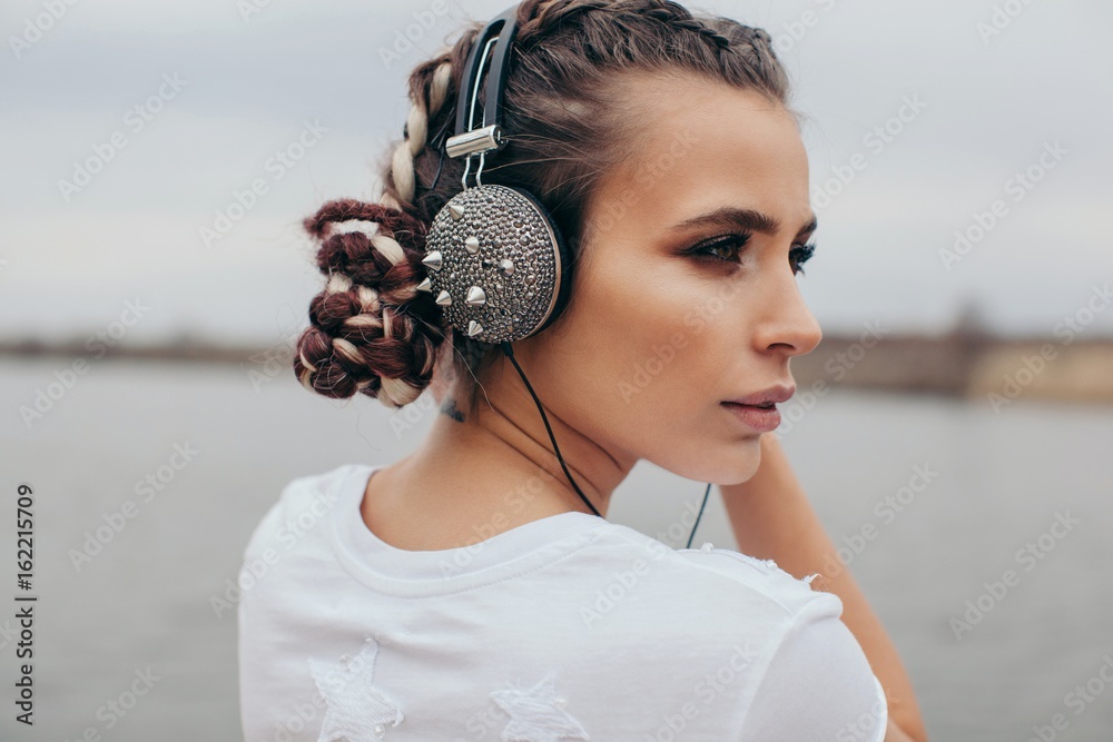 Portrait of a smiling woman wearing spiked headphones Stock Photo