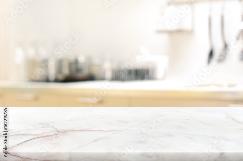 Marble stone table top (kitchen island) on blur kitchen interior background photo