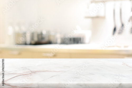 Marble stone table top (kitchen island) on blur kitchen interior background