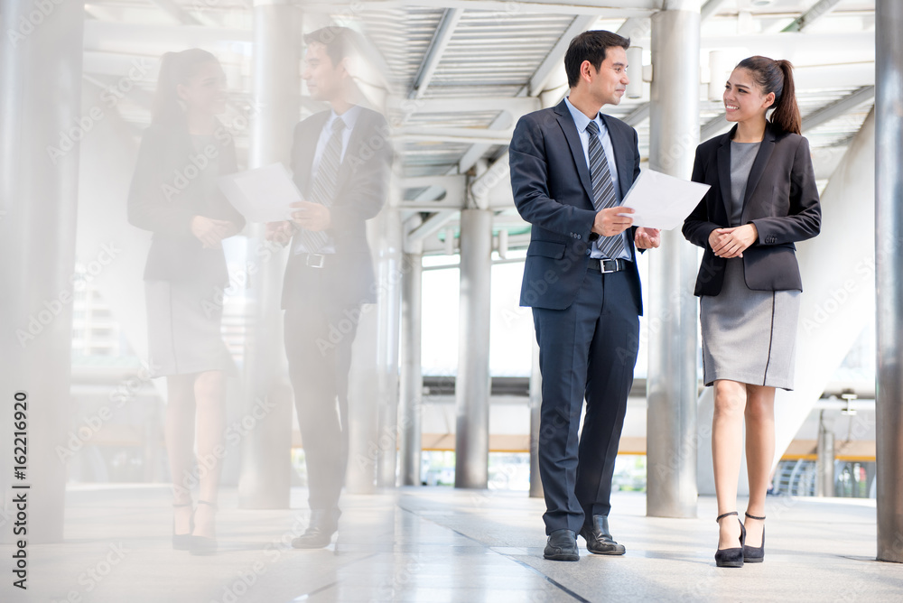 Fototapeta premium Businessman and businesswoman discussing work while walking