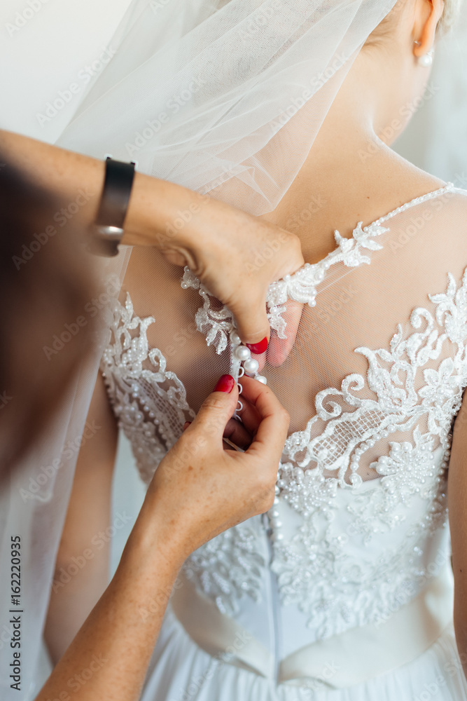 Gorgeous  bride in white dress getting ready for wedding ceremony
