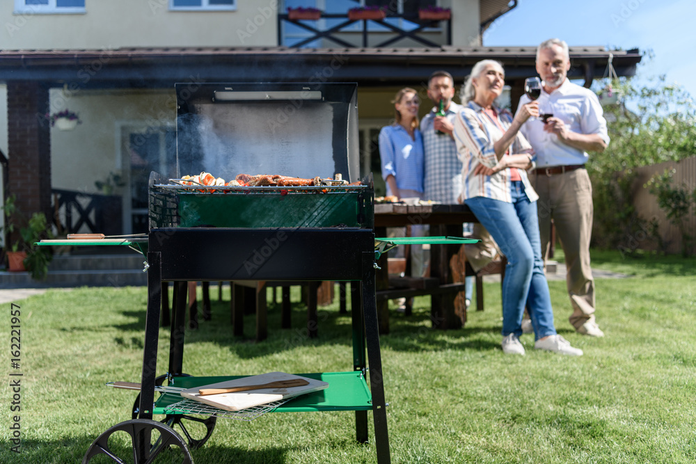 family spend time together while having barbecue with grill at yard